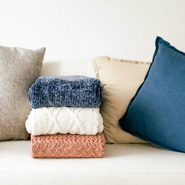 Une pile de 3 pulls en laine pour un dressing minimaliste. Les essentiels pour le minimalisme dans sa garde-robe
