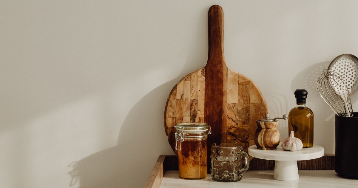 minimalisme en cuisine, des épices, des huiles et des herbes, planche à découper en bois sur plan de travail rangé