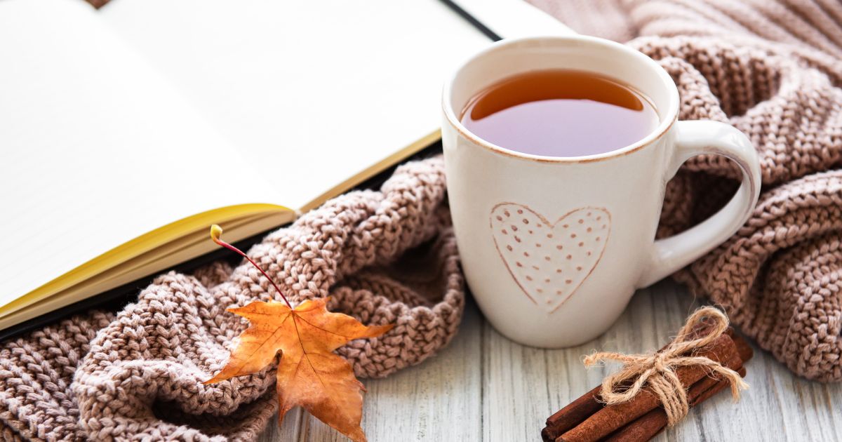 Une tasse, un carnet et une feuille d'automne, pour des activités slow life en automne